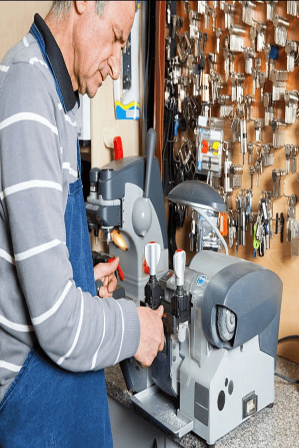 Locksmith operating professional key cutting machine during residential service in Aiken SC