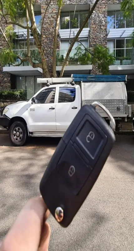 Automotive locksmith replacing car key in Aiken SC parking lot